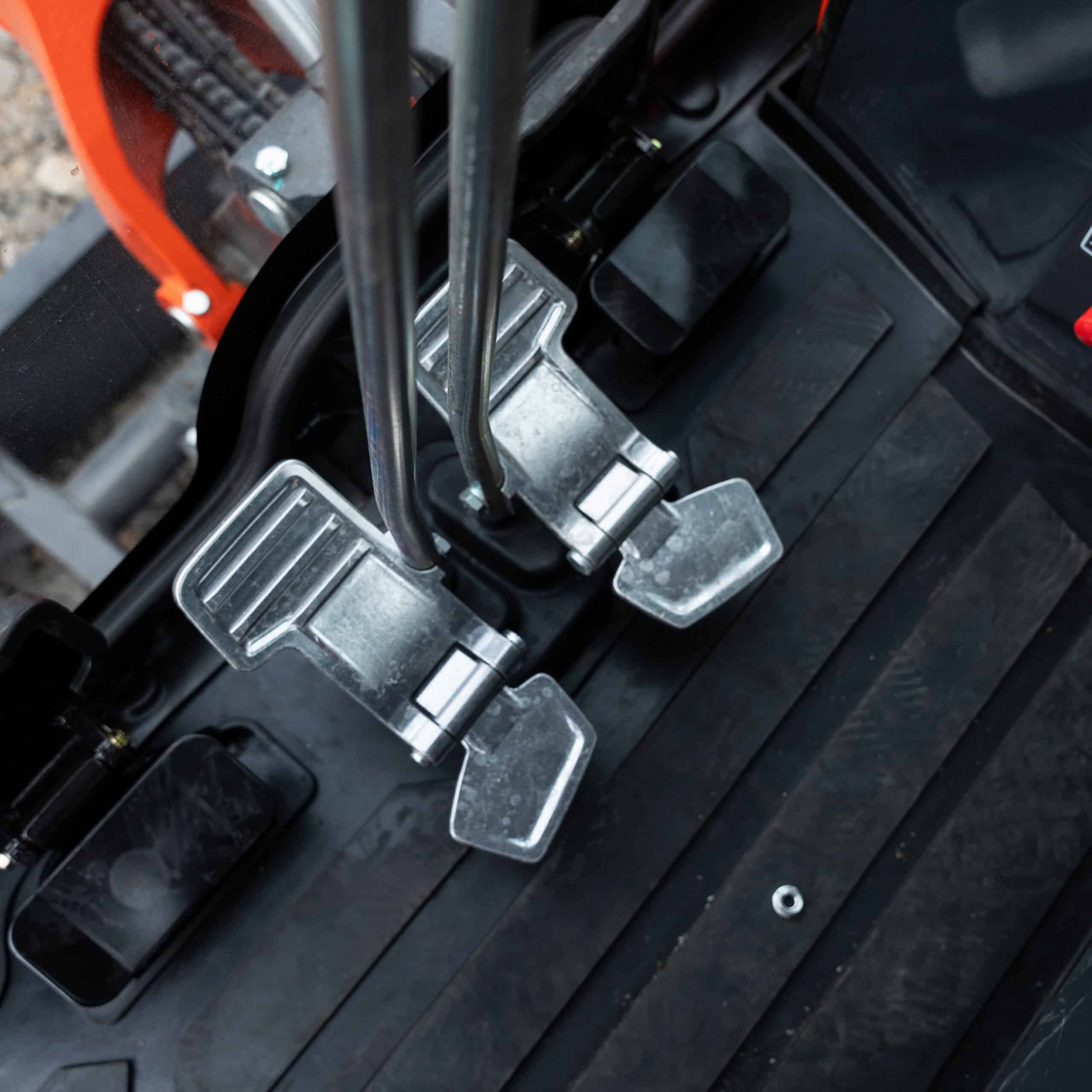 Close-up of metallic pedals on construction machinery for operation control.