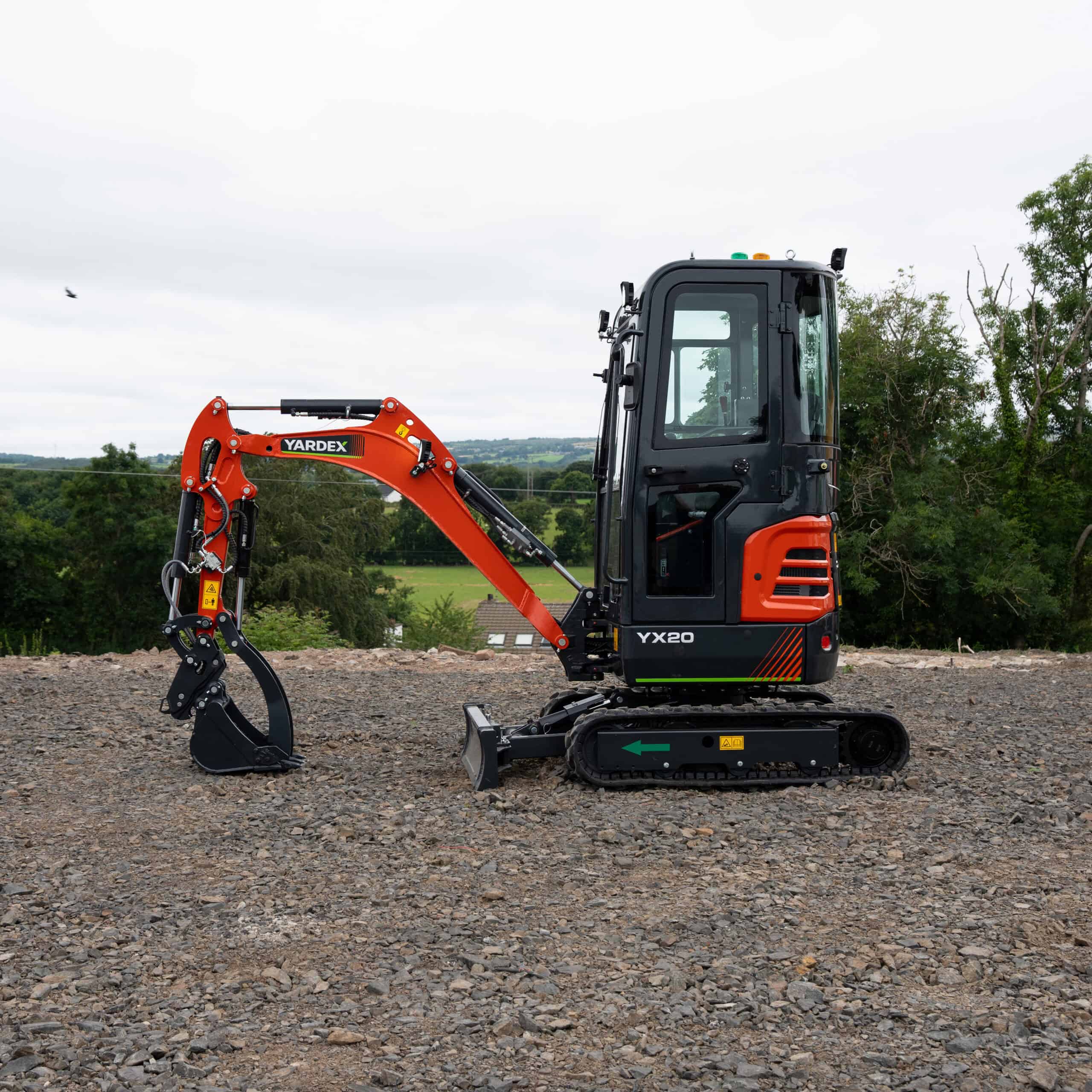 Yardex compact mini excavator on construction site with tracked wheels.