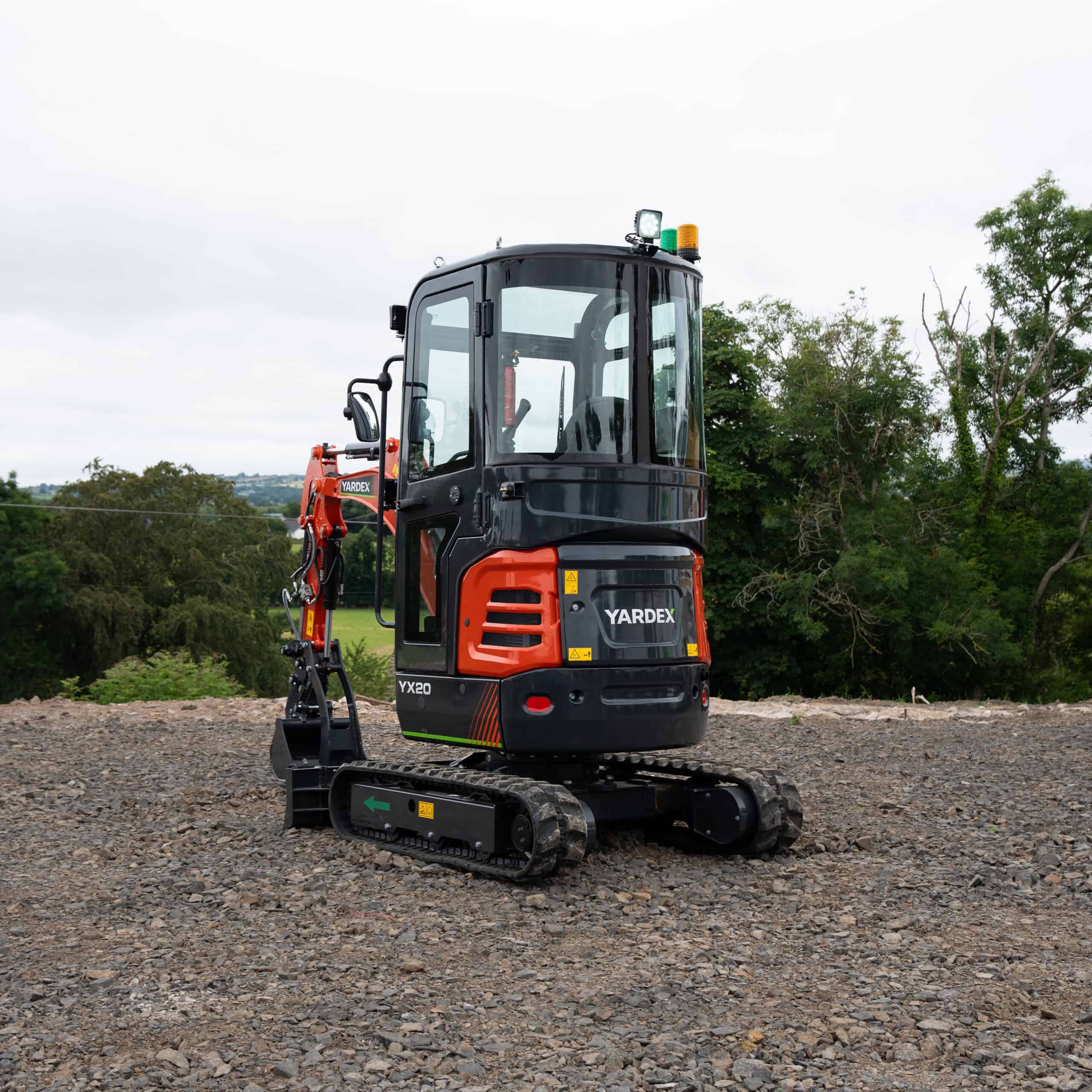 Compact Yardex mini excavator on construction site with tracked wheels.