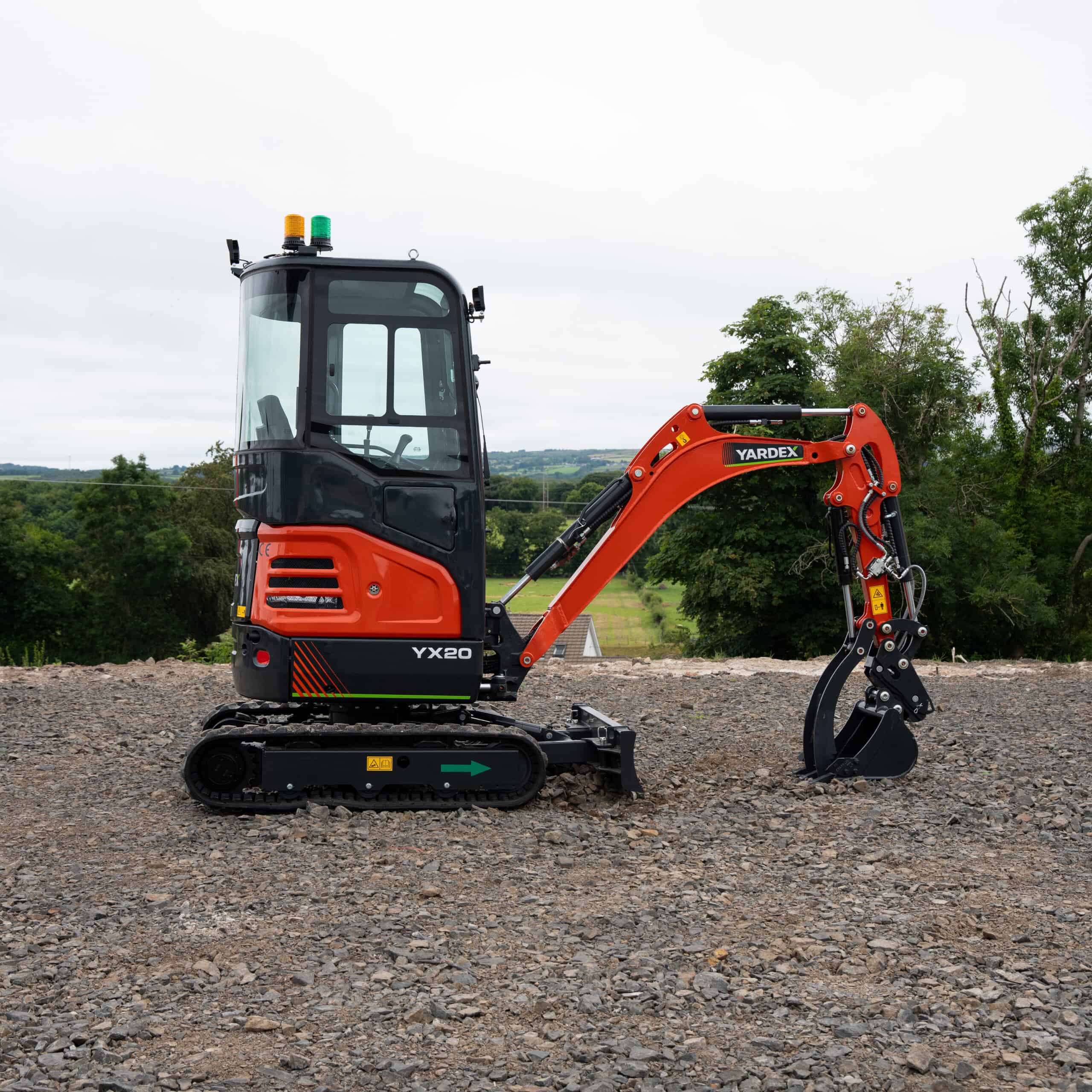 Compact Yardex mini excavator on construction site with tracked wheels.