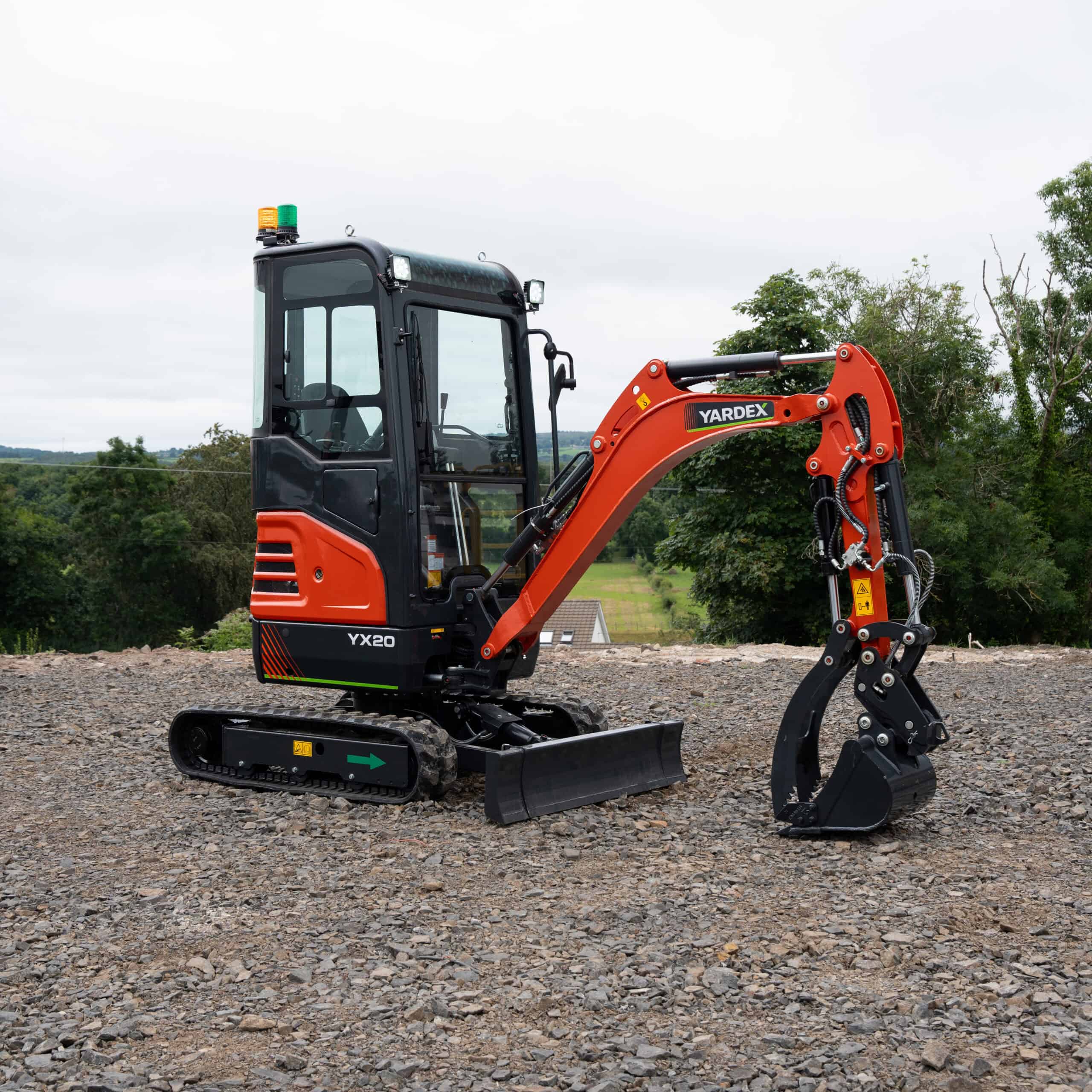 Yardex mini excavator on construction site with tracked wheels and hydraulic arm.