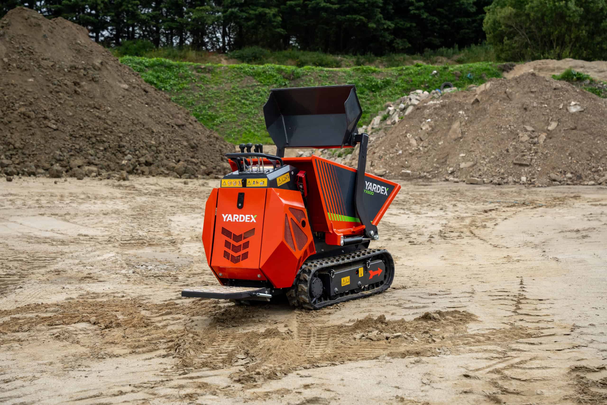 Yardex Group mini tracked dumper on construction site with soil piles.