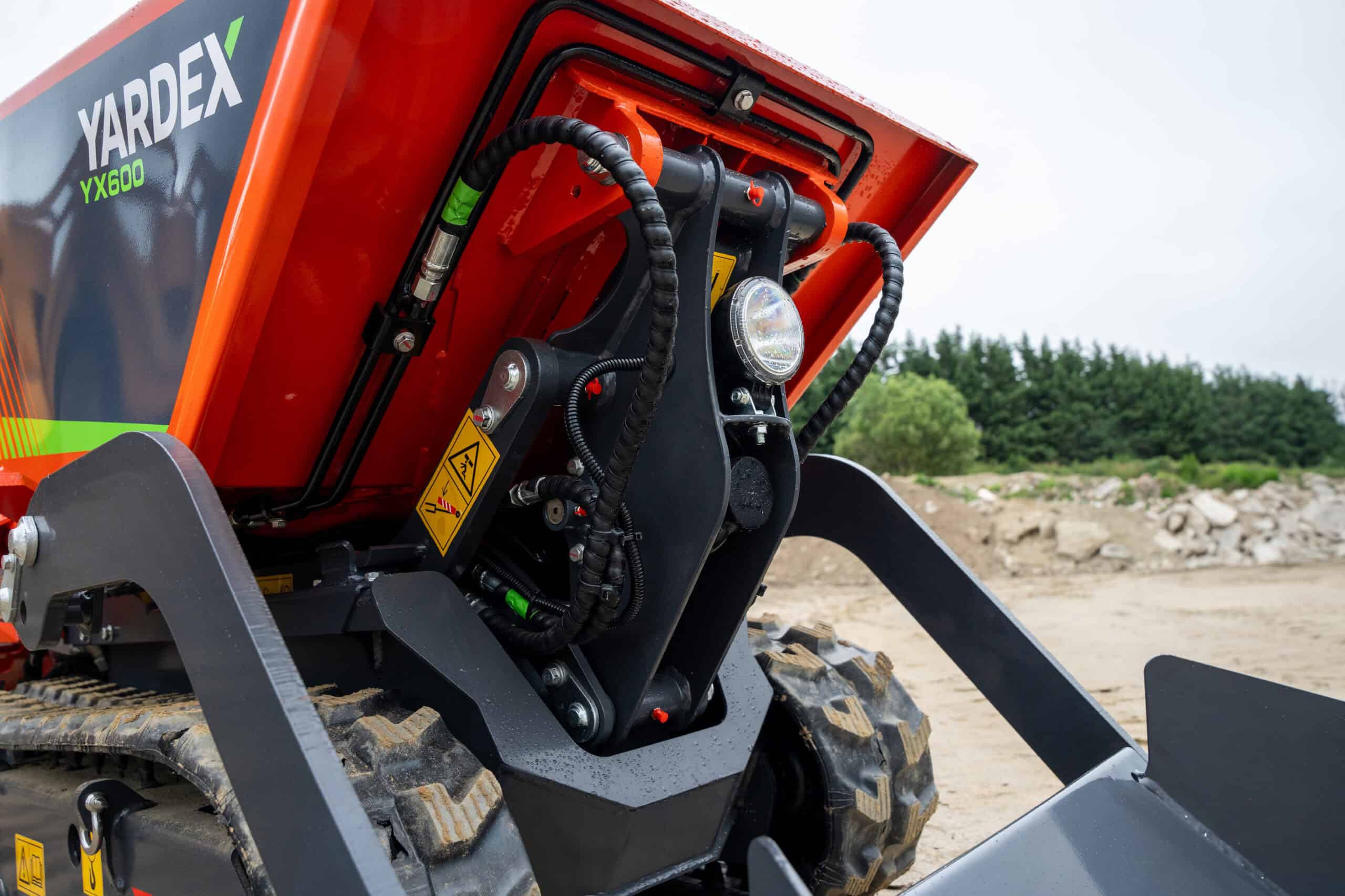 Close-up of Yardex Group compact construction machinery with hydraulic system details.