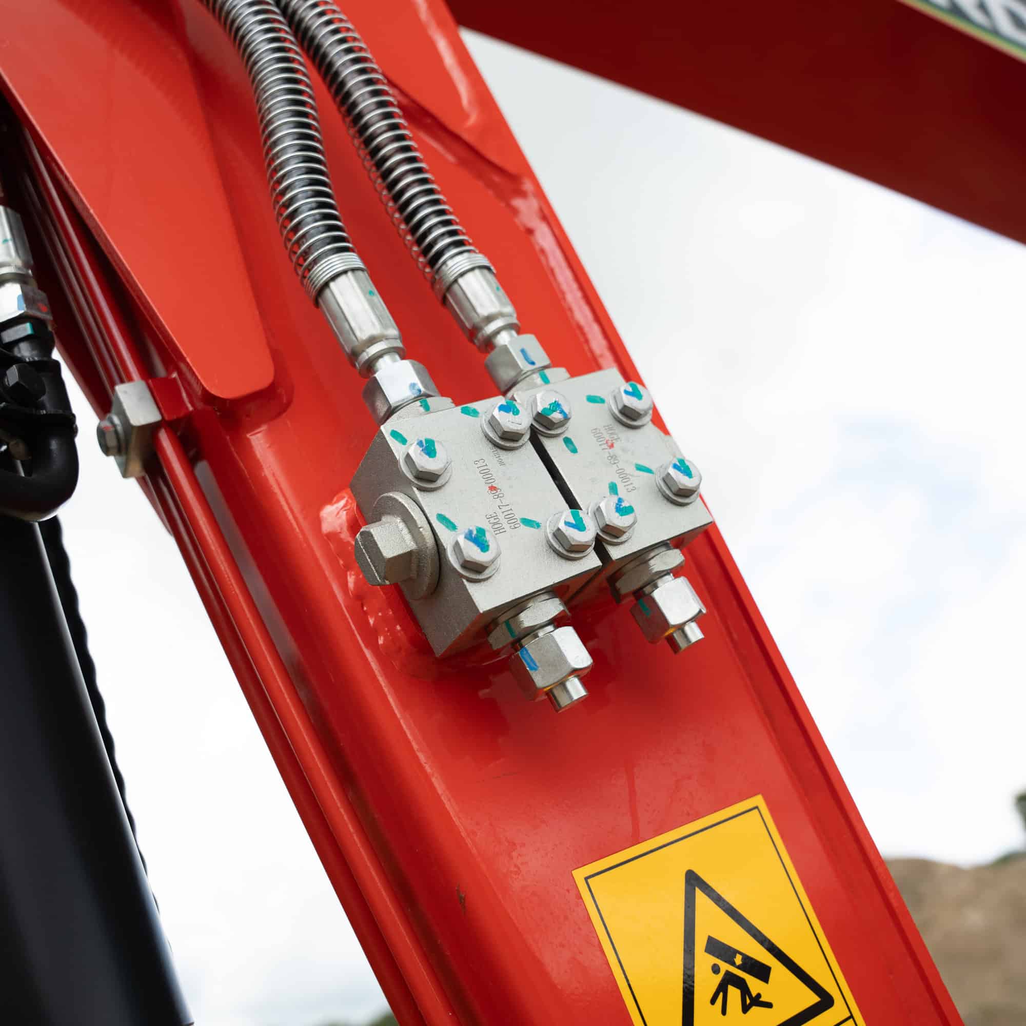 Close-up of hydraulic hoses and fittings on construction equipment.