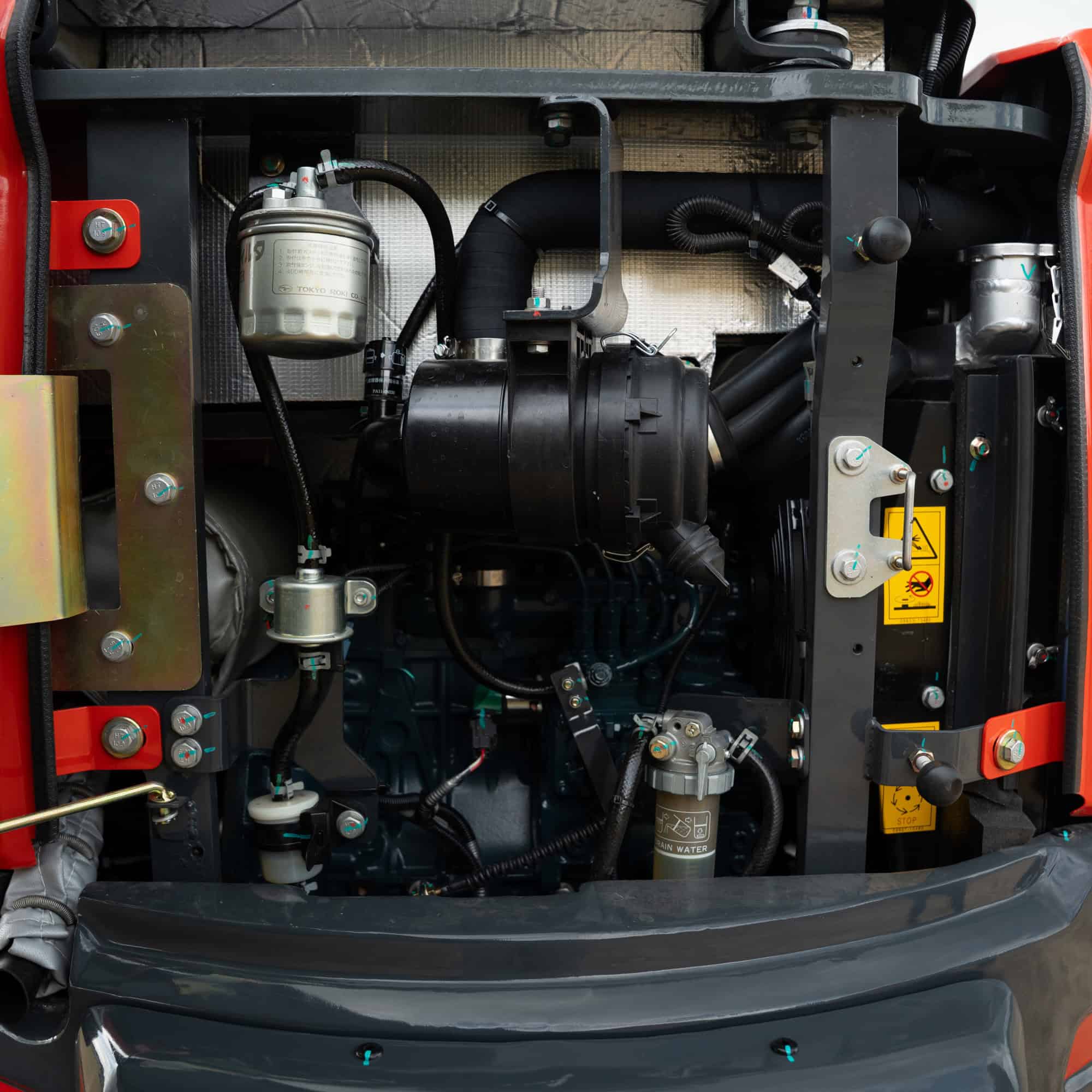 Close-up of Yardex Group heavy machinery engine components and hydraulic system.