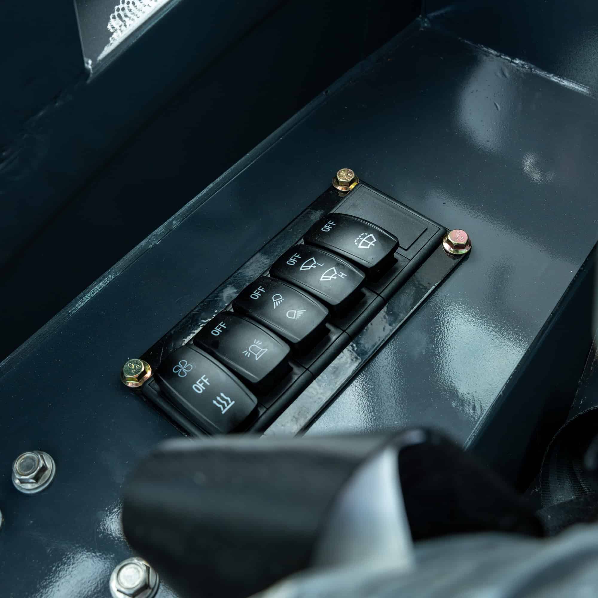 Close-up of control switches on Yardex Group heavy machinery.