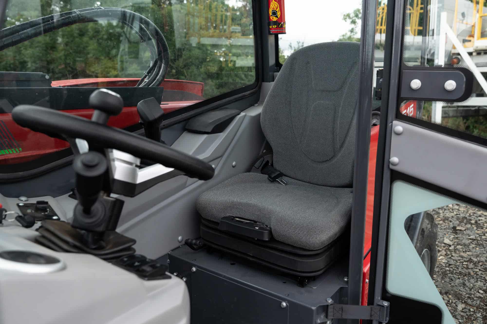 Close-up of a construction vehicle cabin with seat and controls.