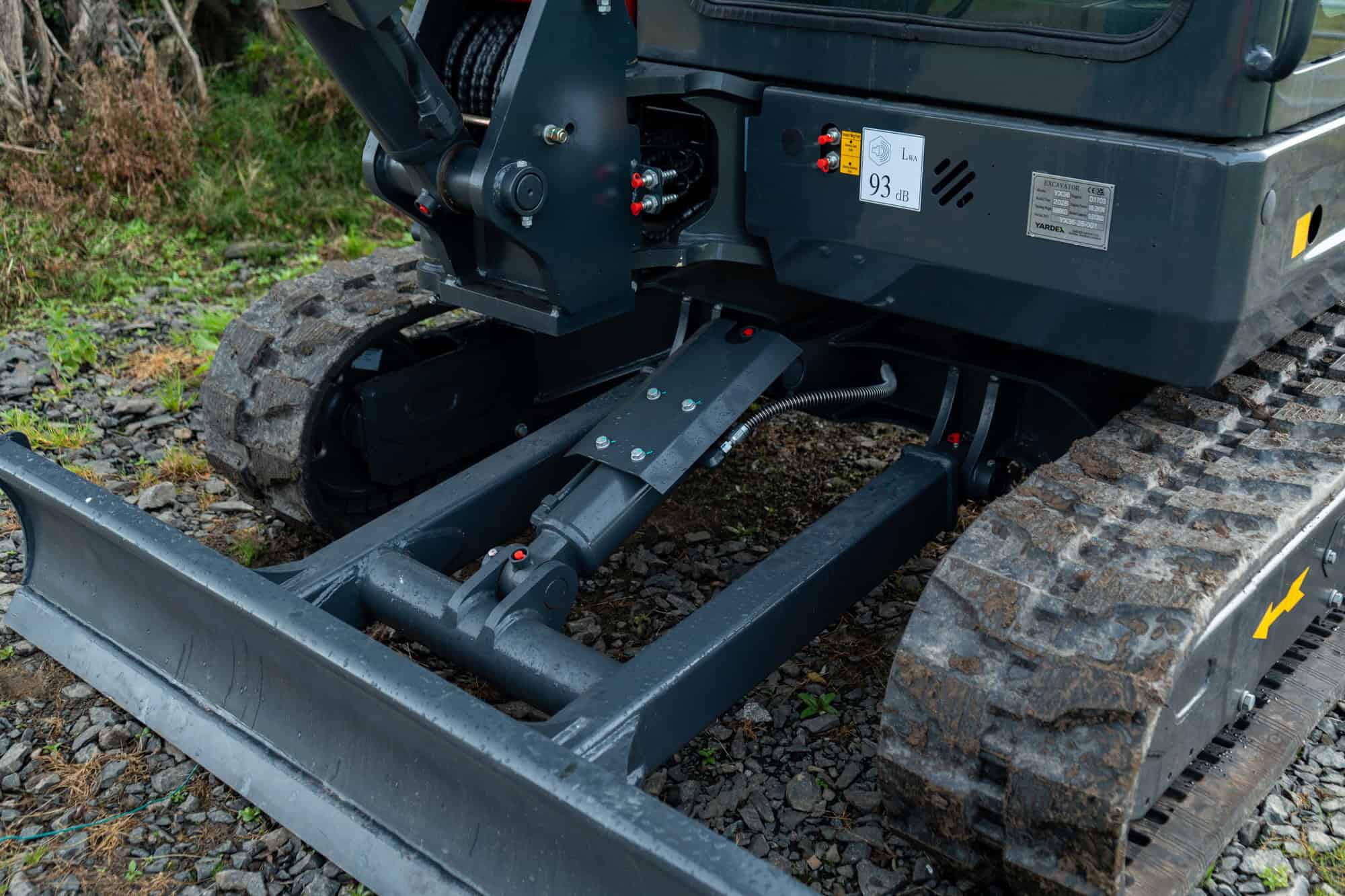 Close-up of a compact excavator with tracked wheels and hydraulic arm.
