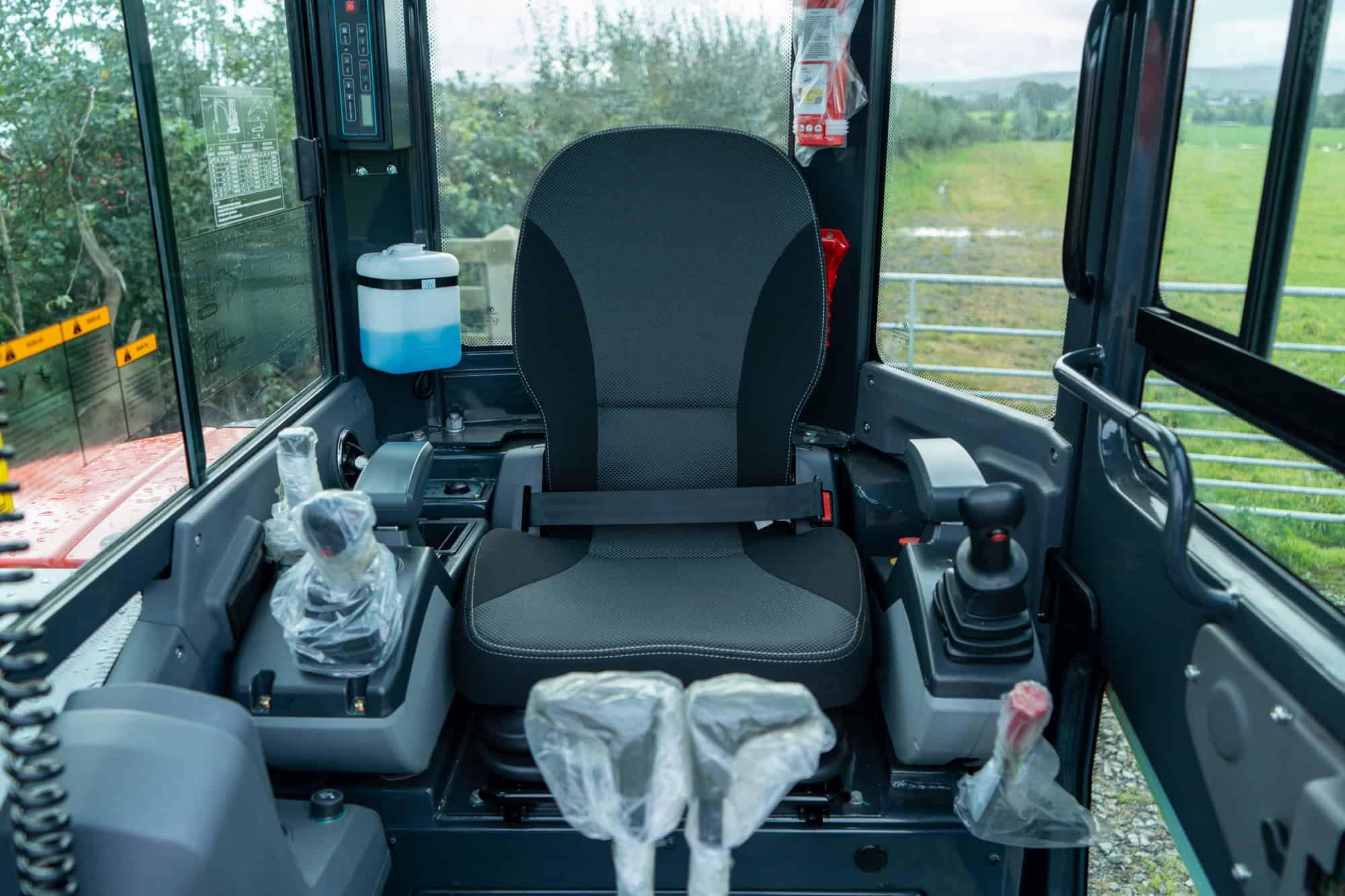 Inside view of a modern excavator cabin with controls and seat.